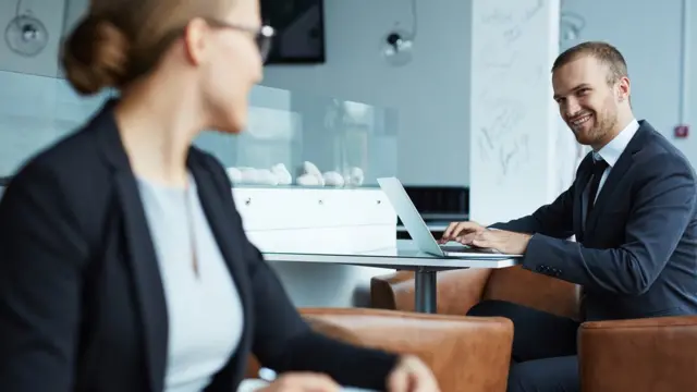 Colegas en el trabajo sonríen mutuamente