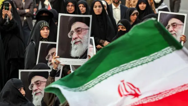 Bendera Iran berkibar di depan demonstran perempuan yang mengangkat foto Pemimpin Tertinggi Iran Ayatollah Ali Khamenei selama unjuk rasa anti-Israel di Teheran pada 24 Oktober 2024