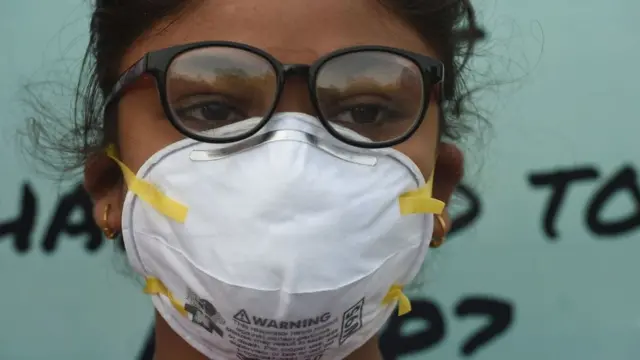 মুখে মাস্ক পরে বায়ু দূষণের প্রতিবাদ করছে এক ছাত্রী।