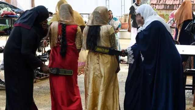 কলম্বোর একটি মসজিদে প্রবেশের আগে দুজন মুসলিম নারীর শরীরে তল্লাশি চালানো হচ্ছে।