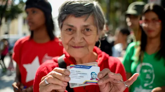 Mulher mostra seu carnê da pátria