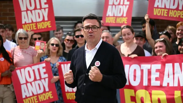 Andy Burnham, Makerfield bölgesindeki ara seçimlerde kampanya sırasında "Andy'ye oy verin, umuda oy verin" yazılı pankartlar arasında ve desetkçilerinin önünde konuşma yapıyor