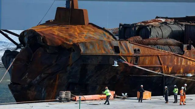 Спасатели осматривают судно Solong после его буксировки в гавань Абердина 28 марта 2025 года. 