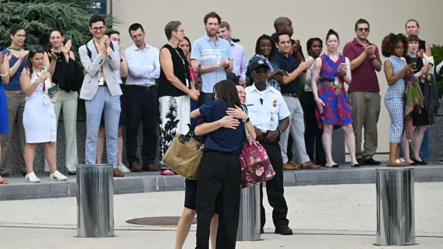 国務省の外で大勢が拍手する中、抱き合う女性たち