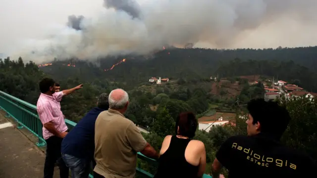 Несколько человек с моста наблюдают за зоной пожара