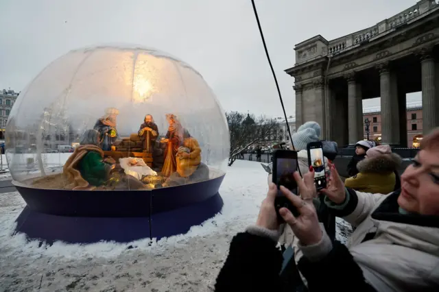 Ljudi gledaju instalaciju jaslica u blizini Kazanjske crkve uoči proslave Nove godine i Božića u Sankt Peterburgu, Rusija, 24. decembra 2025. Rusi se spremaju da proslave Novu godinu 31. decembra i Božić, koji se obeležava 7. januara, ruskom pravoslavnom julijanskom kalendaru.