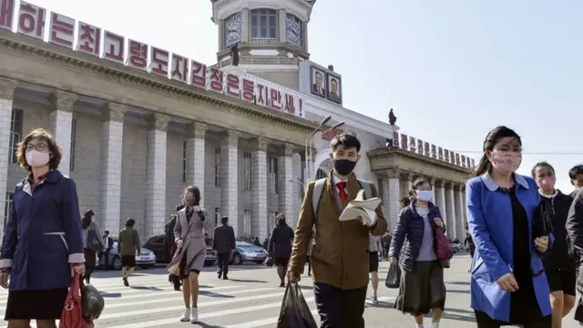 পিয়ং ইয়ংএ রেল স্টেশনের বাইরে মাস্ক পরা লোকজনকে দেখা যাচ্ছে