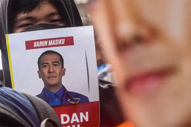 Seorang mahasiswa membawa poster Harun Masiku saat melakukan aksi unjuk rasa di depan Gedung KPK Merah Putih, Jakarta, Selasa (17/12).