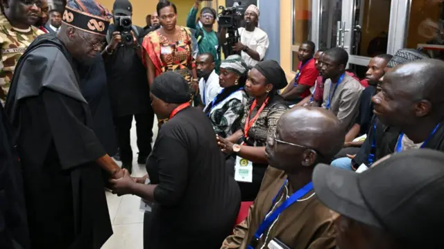 President Bola Tinubu dey console Favour Rhoda wey her son die for di attack. Both of dem wear black. 