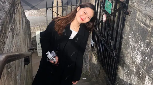 28岁的杰奎琳·崔侧身微微向左倾,面带微笑地拍照。