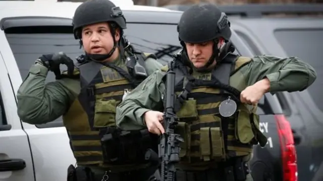 துப்பாக்கி சண்டை நடந்த இடத்தில் போலீஸ் அதிகாரிகள்