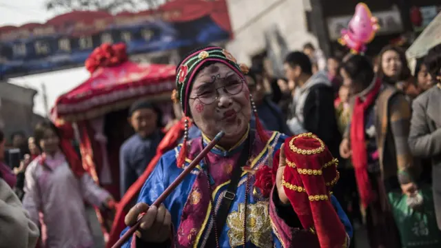 Chinese woman dressed with a traditional costume, attends a wedding performance as part of the She Huo festival, to celebrate the Lunar New Year, marking the Year of the Dog, in Hancheng, Shaanxi province, on February 16, 2018.