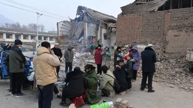 中国・甘粛省での地震発生から夜が明け、火を起こして暖を取る被災地の住民ら（19日）