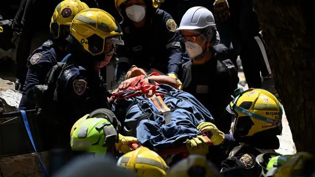 Equipos de rescate sacan a un herido entre los escombros. 