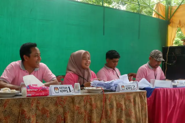 Petugas KPPS 03 Kelurahan Gunung Sekar, Kecamatan Sampang kompak berseragam warna pink dan menghias TPS dengan bunga. Langkah ini dilakukan untuk membuat suasana Pilkada Sampang lebih adem.