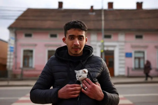 Abdullah Elkobbi, 21, a medical student from Morocco, who is fleeing Russia"s military operation against Ukraine, holds his cat as he waits in line to reach the Shehyni border crossing to Poland, outside Mostyska, Ukraine, February 27, 2022. He said: "I love this country. I"m so sad that it will be destroyed".