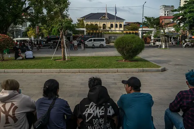 Warga negara Indonesia yang terbebas dari pusat penipuan berkumpul dan menunggu di luar KBRI, tidur dan beristirahat di trotoar dengan membawa barang-barangnya, seperti yang terlihat di Phnom Penh, Kamboja, pada 22 Januari 2026.