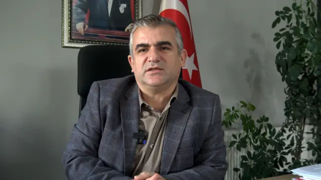 Temel Cengiz bir masada otururken