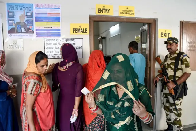 हरियाणा के एक मतदान केंद्र पर वोट देकर बाहर निकलती महिला मतदाता