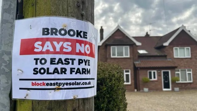 Un primer plano de un poste de telégrafo con un cartel pegado que dice "Brooke dice no al parque solar de East Pye".