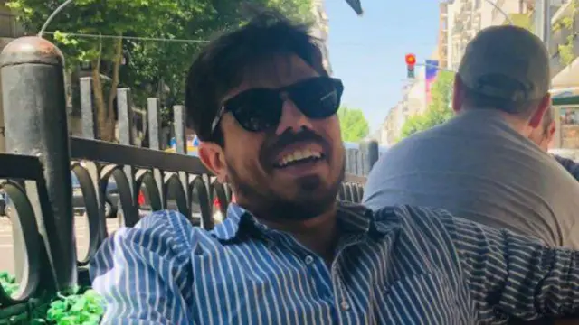 Pedro Nogueira sentado e sorrindo, aparentemente na área externaaposta ganha tottenhamum restaurante