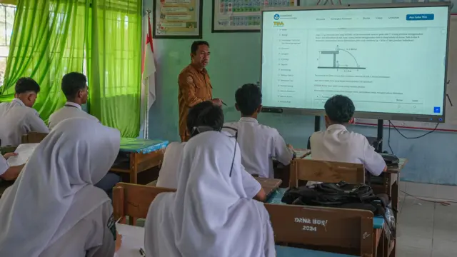 Guru mengajar menggunakan layar digital pintar di SMA Negeri 2 Kendari, Sulawesi Tenggara, Senin (27/10/2025).
