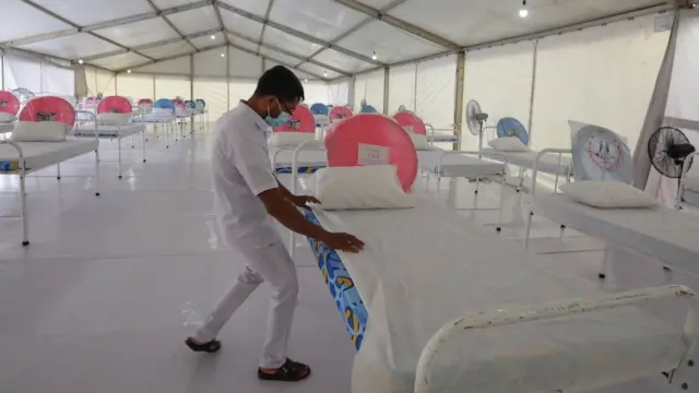 A health worker arranges the beds at a new ward facility for patients suffering from COVID-19 at a regional hospital in Colombo, Sri Lanka, 12 May 2021