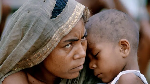 انڈیا کے شہر کلکتہ میں لگائے جانے والے پناہ گزینوں کے ایک کیمپ میں ایک بنگلہ دیشی خاتون اپنے بچے کے ساتھ۔ جنگ کے دوران لاکھوں بنگلہ دیشی پناہ کے لیے انڈیا چلے گیے تھے
