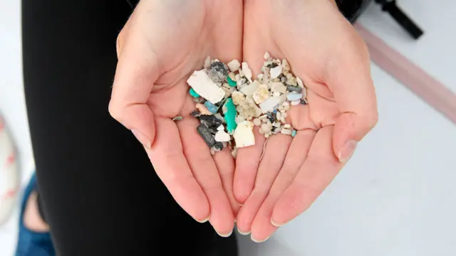 Manos con un puñado de microplásticos