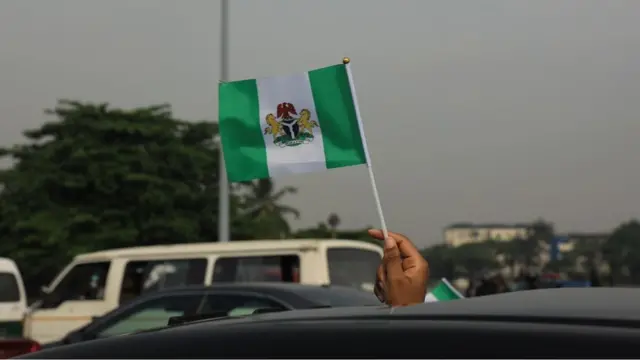 Pesin wave Nigeria flag on di End Sars protest one year anniversary for Lekki Tollgate