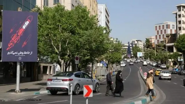 Эрон пойтахти Теҳрон кўчасида ўтаётган одамлар
