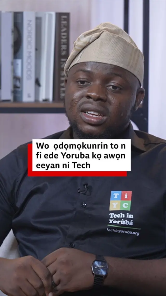  Theophilus Adegbohungbe to n fi ede Yoruba kọ awọn eeyan ni Tech wọ asọ sokoto ati ẹwu olomi aro ati fila alawọ goolu