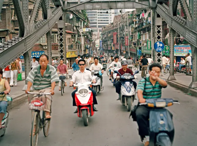 Pessoas andando de scooter em Xangai