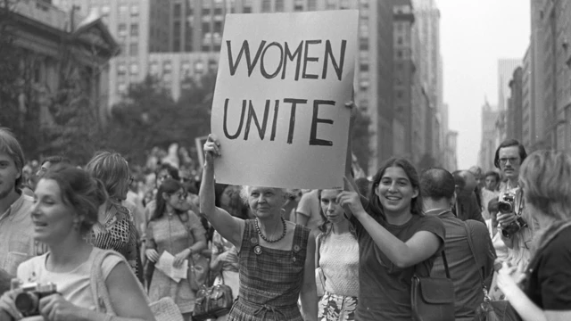 Uma mulher mais idosa e uma jovem seguram um cartaz dizendo 'Mulheres Unidas', enquanto marcham, com outras mulheres, pela Quinta Avenida, em Nova York (EUA)
