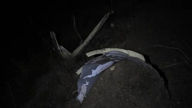 На темному фоні на землі уламки 