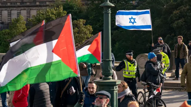 صورة للعلم الفلسطيني وفي الخلفية يظهر العلم الإسرائيلي خلال مظاهرة مؤيدة للفلسطينيين في اسكتلندا