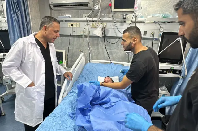 الدكتور حسام أبو صفية مع جرحى في مستشفى كمال عدوان 