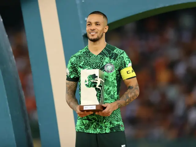 Le défenseur nigérian William Troost-Ekong brandit le Ballon d'Or de la CAN, à l'issue de la finale de la CAN 2024 opposant la Côte d'Ivoire au Nigeria à Abidjan, le 11 février 2024. 