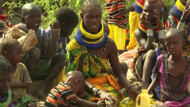 Abana bananutse kubera inzara, bamwe bafise imifuko igaragara, bahagaze hanze y'ikigo gitanga imfashanyo, bararindiriye kugira barabe ko hari ico boronka