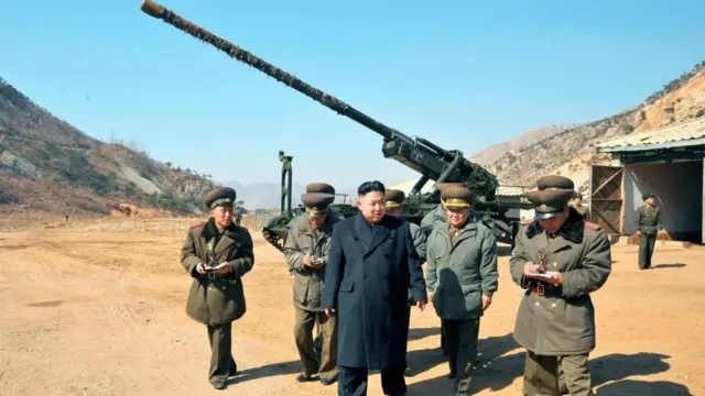 Nhà lãnh đạo Triều Tiên Kim Jong-Un đứng trước một đơn vị pháo binh tầm xa
