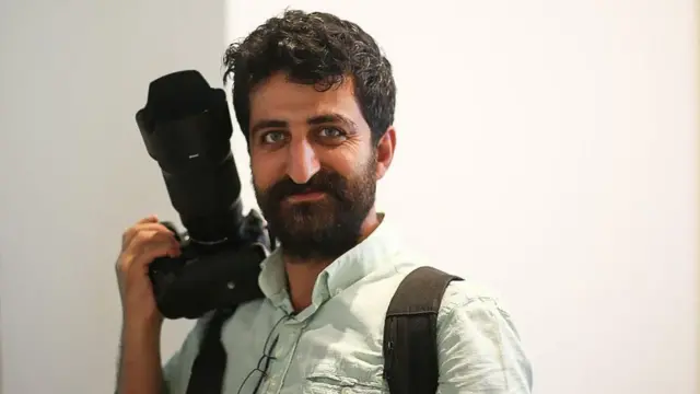 यासीन अक्गुल अपने हाथ में कैमरा पकड़े हुए