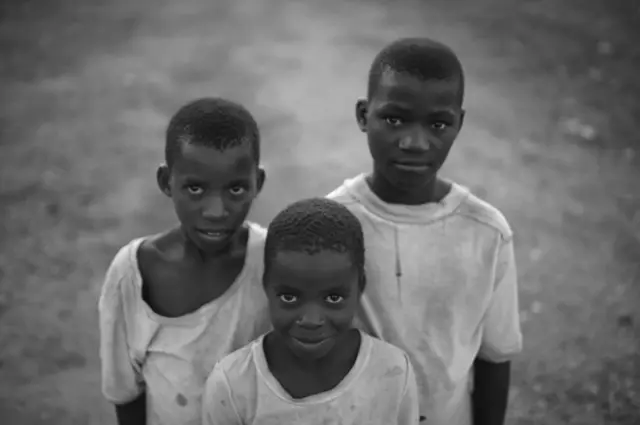 Three boys smile for the camera.