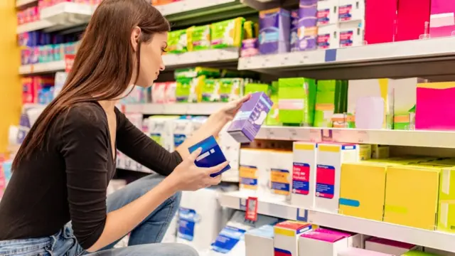 Una mujer observa productos sanitarios en un supermercado.