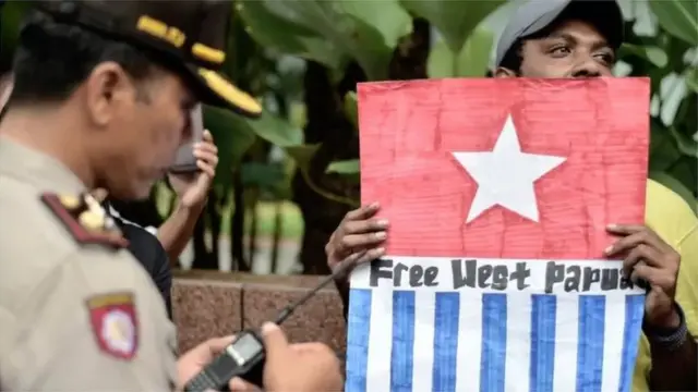 Seorang pengunjukrasa membawa simbol bendera Bintang Kejora menuntut pemisahan Papua dari Indonesia dalam demo pada April 2017 di Jakarta.
