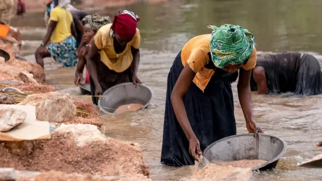 Des mineurs artisanaux ramassent du gravier dans la rivière Lukushi à la recherche de cassitérite - le principal minerai d'étain - à Manono, en République démocratique du Congo.