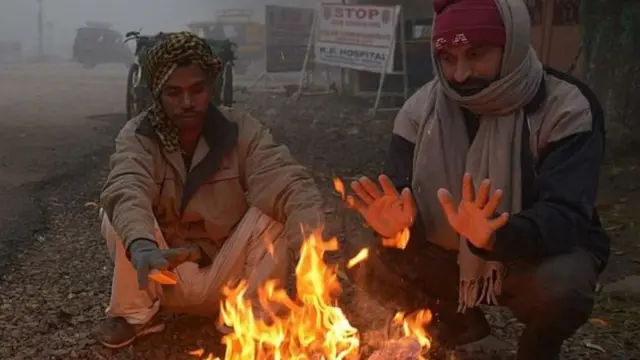 તાપણું કરતા બે વ્યક્તિ