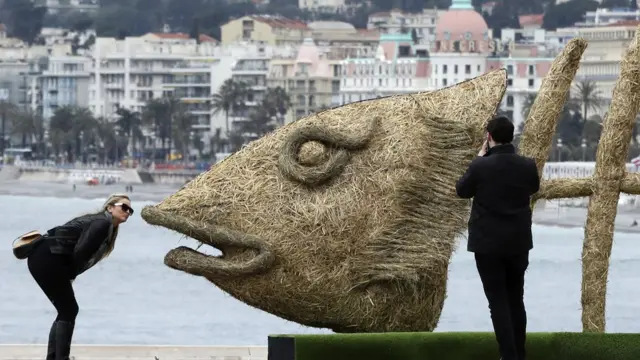 Woman dey kiss sculpture fish