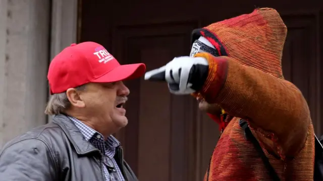 Сторонник Дональда Трампа и участник акции протеста спорят во время "Женского марша на Вашингтон" 21 января 2017 г.