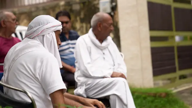 राधिका यादव के घर के बाहर बैठे रिश्तेदार