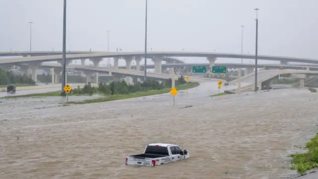 un auto queda inundado en medio de un carretera